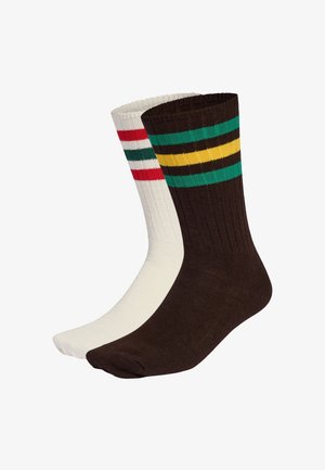 Calzini di cotone in marrone e bianco. Il calzino marrone presenta strisce verdi, gialle e nere; il calzino bianco ha strisce rosse e verdi. Tessitura a coste.