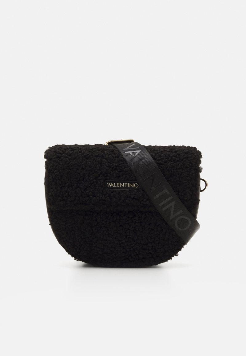 Sort crossbodytas lavet af tekstureret fleece-materiale, med en flad frontpanel, guldfarvet logodetalje og en sort rem med logodetaljer.