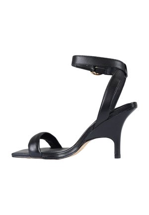 Sandalo con tacco alto in pelle nera con sottile cinturino alla caviglia e punta aperta, caratterizzato da una suola anteriore quadrata e un tacco a spillo di media altezza.