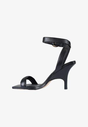 Sandalo con tacco alto in pelle nera con sottile cinturino alla caviglia e punta aperta, caratterizzato da una suola anteriore quadrata e un tacco a spillo di media altezza.