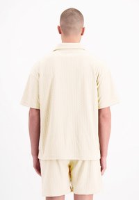 Korte mouwen shirt en korte broek set in lichtbeige met een gestructureerd zigzagpatroon, met een relaxte pasvorm en een klassieke kraagontwerp.