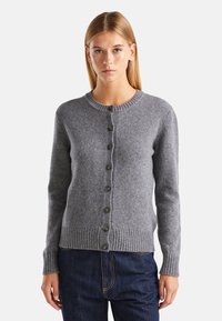 Cárdigan gris de punto con cuello redondo, cierre de botones, puños acanalados y dobladillo. Textura suave con botones lisos en la parte delantera.