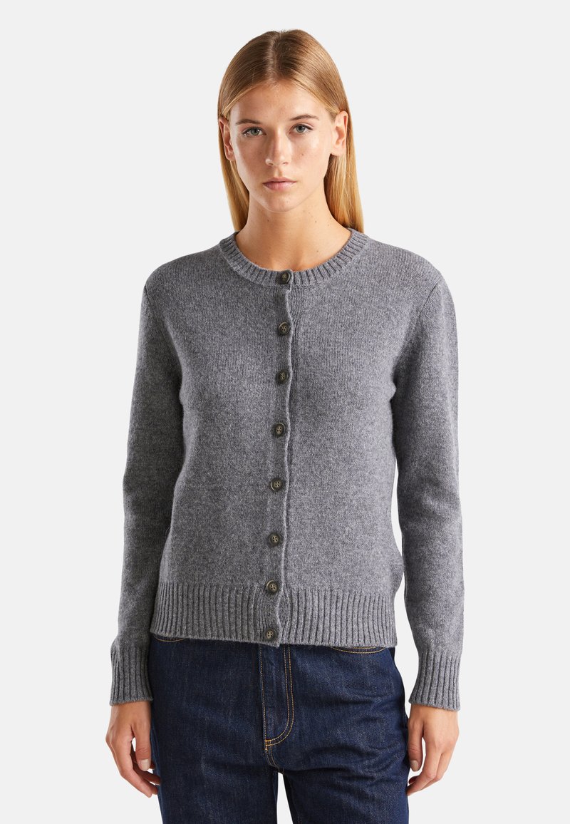 Cárdigan gris de punto con cuello redondo, cierre de botones, puños acanalados y dobladillo. Textura suave con botones lisos en la parte delantera.