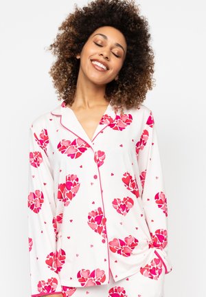 Witte pyjama set met roze hartpatronen en kleine rode harten. Langsleeve-top met een kraag, knopen en een ontspannen pasvorm.