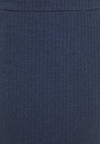 Tissu bleu marine à motif en chevrons, avec une texture lisse et un léger éclat, adapté aux vêtements sur mesure ou à la tenue professionnelle.