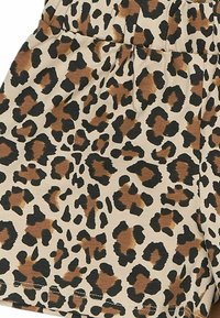 Pantaloni corti con stampa leopardata con uno sfondo beige e macchie nere e marroni. Realizzati in tessuto testurizzato con una cintura elastica.