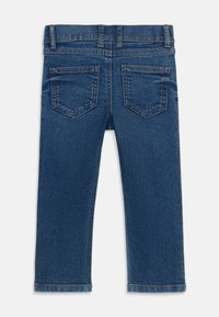 Τζιν παντελόνι με μεσαία μπλε απόχρωση, ίσια γραμμή, δύο πίσω τσέπες με ραμμένες περιγράμματα και περιποιημένο τελείωμα.