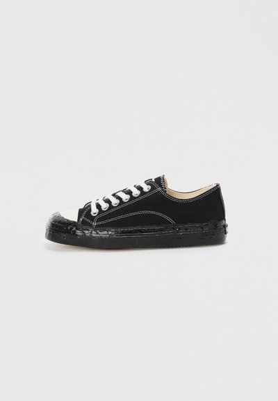 Sneakers neri in tela con lacci bianchi, punta in gomma e suola testurizzata nera. Presentano cuciture bianche e un design a taglio basso.