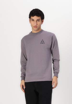 Langærmet, lavendel bomulds t-shirt med rund hals og lille trekantet logo i mørkegrå på venstre bryst. Casual og afslappet pasform.