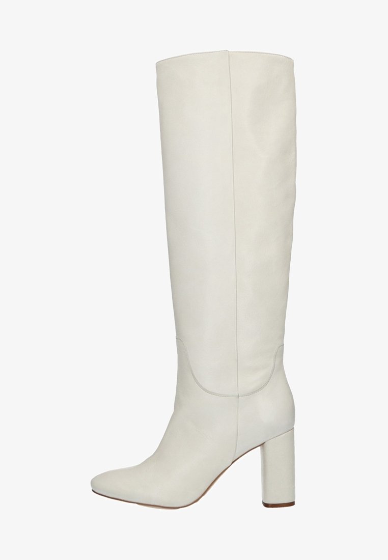 Botte blanche en cuir montant jusqu'au genou avec bout arrondi et talon bloc, finition lisse et détails de couture sur la tige et le pied.