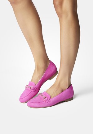 Lyserøde ruskinds loafers med flad sål, prydet med en dekorativ kæde foran. Glat overflade og rund tådesign.