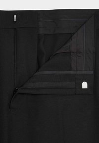 Czarne spodnie z zamkiem błyskawicznym z przodu, o gładkiej fakturze materiału oraz metalowymi elementami do zapięcia.