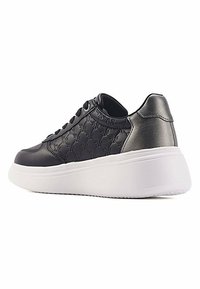 Schwarze Leder-Sneaker mit strukturiertem Obermaterial, weißer Plattformsohle und kontrastierendem, metallischem Fersenakzent. Mit Schnürdesign.