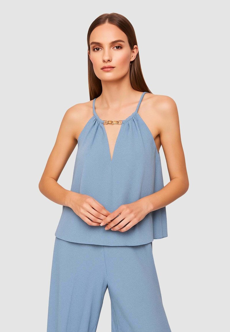 Top azzurro chiaro senza maniche con scollo a V profondo, tessuto arricciato e dettagli in metallo dorato al collo. Tessuto morbido e fluente.