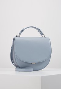 Sac bandoulière en cuir bleu clair avec un rabat arrondi, une bandoulière réglable, des ferrures en argent et une texture lisse.