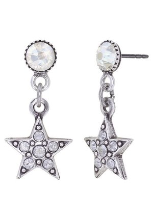 Boucles d’oreilles pendantes en forme d’étoile en argent avec des cristaux ronds translucides et un gros clou en cristal rond sur fond blanc.