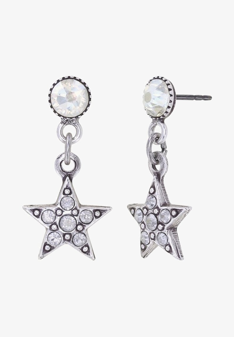 Boucles d’oreilles pendantes en forme d’étoile en argent avec des cristaux ronds translucides et un gros clou en cristal rond sur fond blanc.