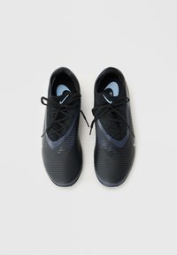 Zapatillas deportivas negras hechas de un material sintético elegante con una parte superior texturizada, con un logo de Nike azul y cordones negros.