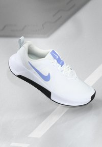 Weißer Sportschuh mit strukturiertem Obermaterial, lila Akzenten, schwarzer Gummisohle und einem Logo an der Seite und Zunge.