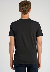 Mustat lyhythihaiset t-paidat, jotka on valmistettu sileästä kankaasta. Pyöreä pääntie ja vartalonmyötäinen leikkaus. Yksinkertainen design ilman näkyviä kuvioita.