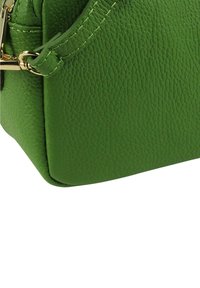 Groene leren handtas met een gestructureerd oppervlak, gouden hardware en een stevige vorm. Voorzien van gestikte details en een veilige sluiting.