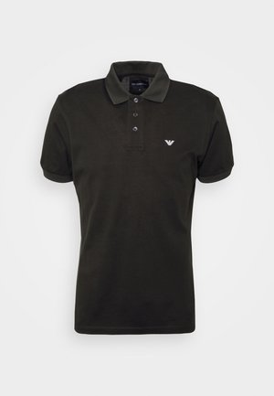 Schwarzes kurzärmeliges Poloshirt mit drei Knöpfen und kleinem weißen Logo auf der linken Brust vor einfarbigem Hintergrund.
