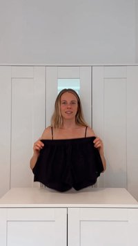 Pantalones cortos negros, holgados y hechos de una tela suave, con una cinturilla elástica, mostrados sobre un fondo blanco.