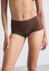 Bruine katoenen ondergoed met een gladde textuur, lage taille en een aansluitende pasvorm. Heeft geen zichtbare naden voor een nette uitstraling.