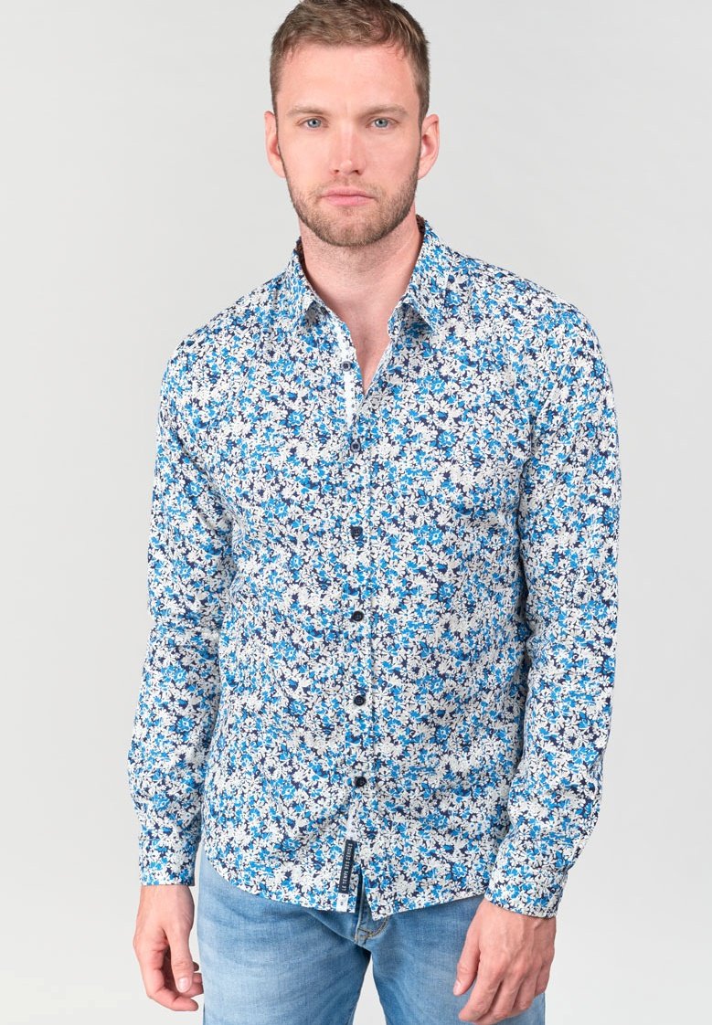 Camicia button-up blu a fiori con intricati motivi floreali bianchi e blu scuro, maniche lunghe e colletto a punta; tessuto leggero.