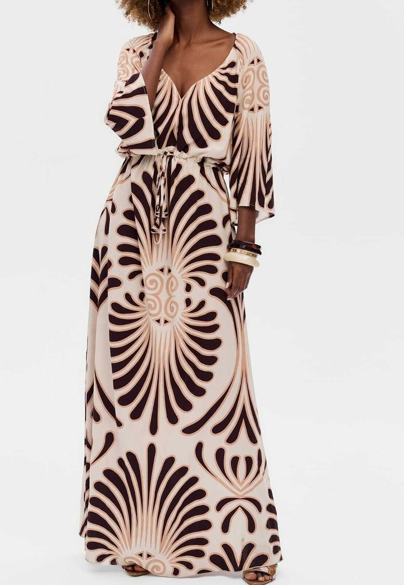 Vestido largo con escote en V profundo, cintura ceñida con cinturón y mangas largas. La tela presenta una base crema con patrones abstractos en marrón intenso.