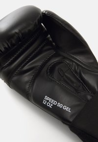 Svart boxhandske gjord av syntetiskt läder, med gelkuddar, en sydd design, och märkt med "SPEED 50 GEL 12 OZ" i vitt.