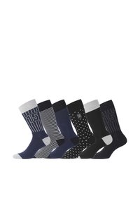 Cinq paires de chaussettes présentant divers motifs : des designs rayés et à pois en bleu marine, noir et gris, avec des poignets et des bouts contrastants.