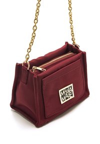 Bolso bandolera de tela burdeos con cadena, cierre con cremallera, herrajes dorados y bolsillo frontal con placa con el logo. Superficie texturizada.