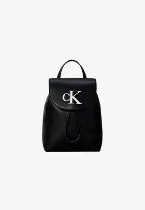 Sac à dos en cuir noir avec fermeture à rabat, cordon, poignée supérieure et logo blanc "cK" sur le rabat avant.