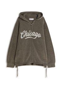 Hnedá mikina na zips s veľkým bielym potlačou "Chicago". Obsahuje šnúrku na stiahnutie a dve bočné vrecká. Mäkká textúrovaná tkanina.