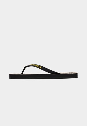 Tongs noires à fines brides, ornées du texte jaune "DSQUARED2", avec une semelle plate et un motif à carreaux sur la semelle intérieure.