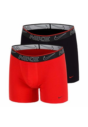 Due paia di boxer Nike, uno rosso e uno nero, entrambi con fascia in vita nera con loghi Nike bianchi e simboli swoosh.
