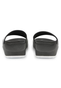 Sandales en caoutchouc noir avec deux brides courbées, semelle intérieure texturée et semelle extérieure blanche. Aucune embellissement ni motif supplémentaire.