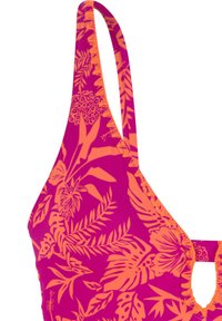 Ljust rosa bikiniöverdel med ett orange tropiskt bladmönster, som har smala axelband och en öppningsdetalj i mitten.