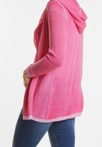 Pink hooded cardigan made of lightweight, textured knit fabric with an open front and contrasting light pink hem. Tailored fit, casual design.