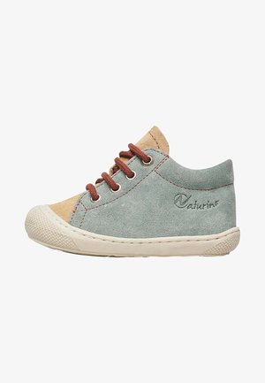 Kinderschuh Sneaker mit niedrigem Schaft aus hellblauem und beigem Wildleder mit braunen Schnürsenkeln und weißer, strukturierter Gummisohle.