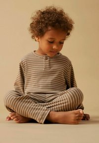 Striped brown cotton pajamas with long sleeves and pants. The design features a button closure at the neck and a soft, textured fabric.