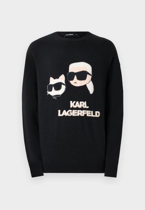 Melna džemperis ar grafiku, kurā attēlots kaķis un cilvēks saules brillēs, ar tekstu "KARL LAGERFELD" izņēmis gaišās krāsās. Mīksta tekstūra, apaļa kakla izgriezums.