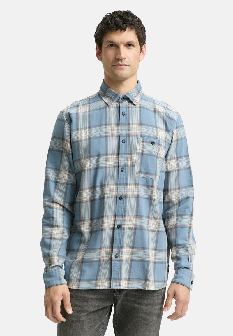Lichtblauw flanellen shirt met een geruit patroon in wit en bruin, met een kraag met knopen, lange mouwen en een borstzak.