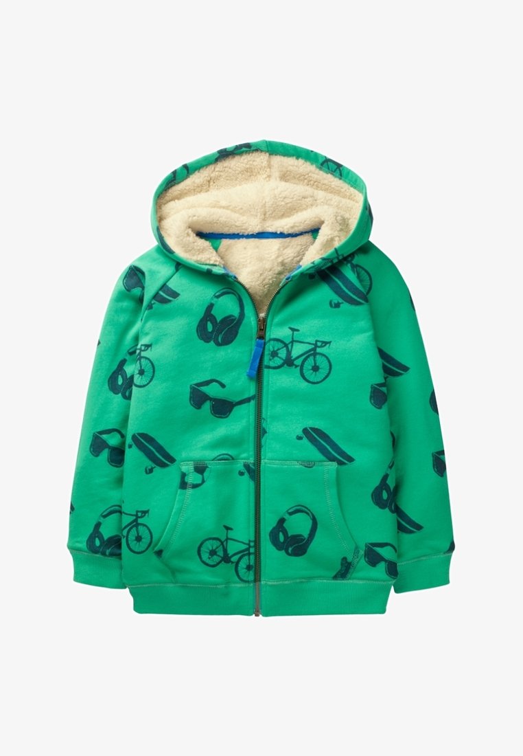 Veste zippée verte pour enfants avec doublure en polaire beige, ornée d'impressions noires de bicyclettes, casques audio, planches à roulettes et lunettes de soleil.