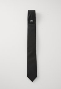 Culoare neagră, cravată dintr-un material neted, cu o textură subtilă, dotată cu un mic accent logo negru aproape de partea superioară.