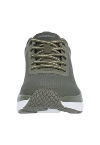 Oliivinvihreä urheilujalkine, jossa on teksturoitu verkkomateriaali, pyöreä kärki, vahvistetut nauhakuopat ja valkoinen pohja, jossa on geometrinen pintakuvio.