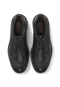 Paar schwarze Leder-Schnürschuhe mit abgerundeten Spitzen und Markeninnensohlen mit der Aufschrift "HUGO" auf weißem Hintergrund.