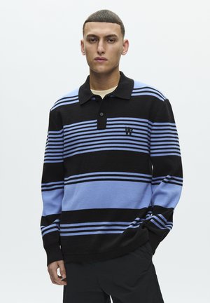 Polo a righe in nero, azzurro chiaro e blu scuro. Presenta un colletto, una patta con bottoni e un logo sul petto. Tessuto a maglia morbido.