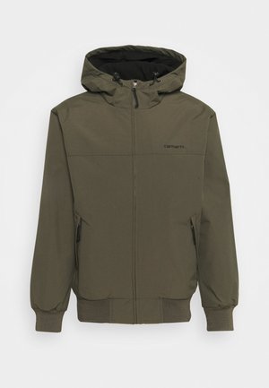 Olive green hooded jacket with a zip front, elastic cuffs, and two side pockets. Features a black lining and a logo on the chest.